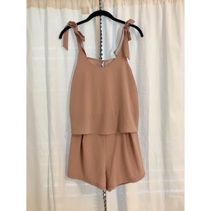 Pink romper with bow straps.